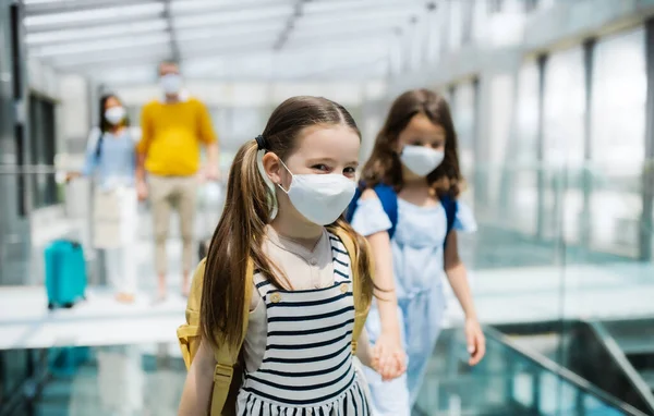 Familia con dos hijos de vacaciones, con mascarillas en el aeropuerto . — Foto de Stock