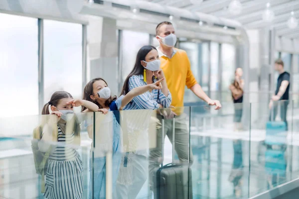 Famiglia con due bambini in vacanza, mascherati in aeroporto . — Foto Stock