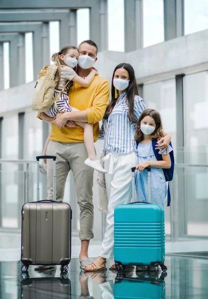 Familia con dos hijos de vacaciones, con mascarillas en el aeropuerto . — Foto de Stock