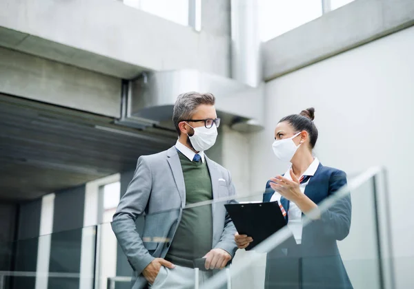 Flight attendant talking to businessman on airport, wearing face masks. — Stock Photo, Image