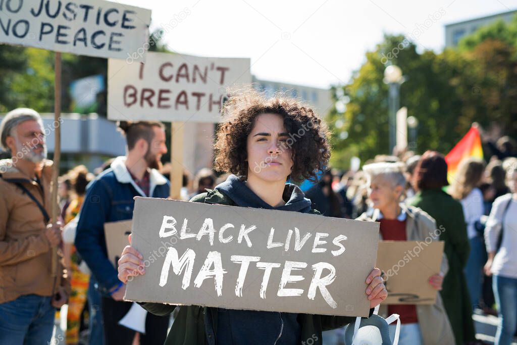 Black lives matters protesters holding signs and marching outdoors in streets.