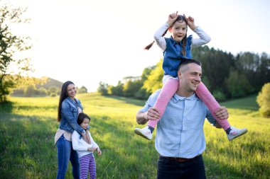 İki küçük kızı olan mutlu bir aile bahar doğasında eğleniyor..