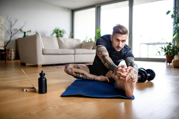 Retrato de vista frontal del hombre con la tableta haciendo ejercicio en el interior de casa . —  Fotos de Stock