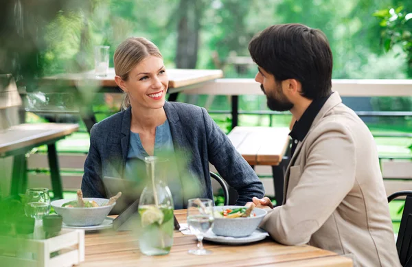 Happy couple sitting outdoors on terrace restaurant, talking. — Stock Photo, Image