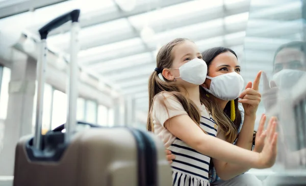 Мати з дочкою їде у відпустку, в аеропорту в масках на обличчі.. — стокове фото