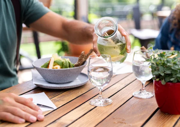 Mittelteil des Paares sitzt draußen auf der Terrasse Restaurant, Mittagessen. — Stockfoto