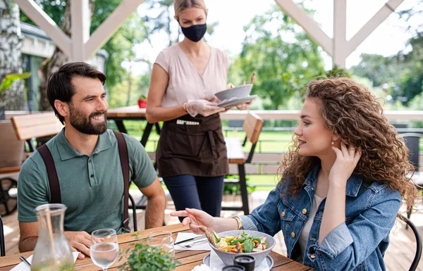 Szczęśliwa para siedzi na zewnątrz na tarasie restauracja, jedzenie. — Zdjęcie stockowe