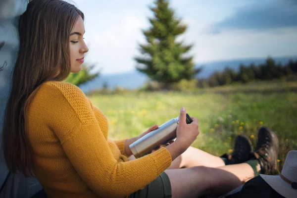 Mladá žena venku na louce v letní přírodě, odpočívá. — Stock fotografie