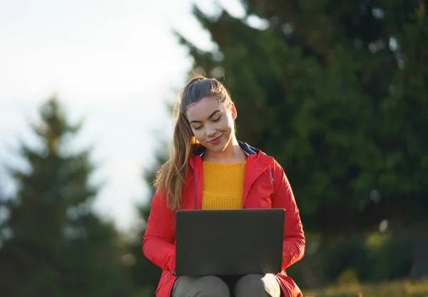 Счастливая молодая женщина, использующая ноутбук на летней природе, концепция открытого офиса. — стоковое фото