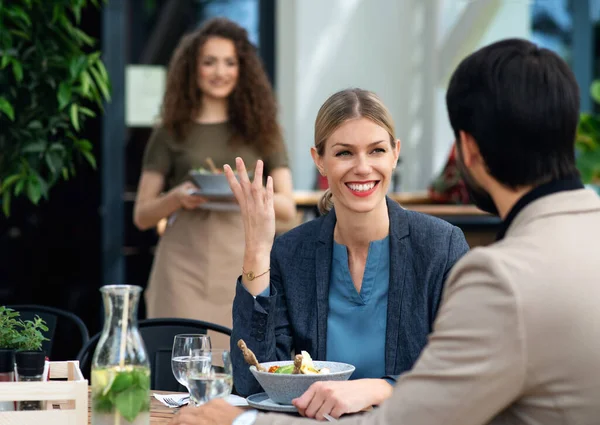 Happy couple sitting outdoors on terrace restaurant, eating. — Stock Photo, Image