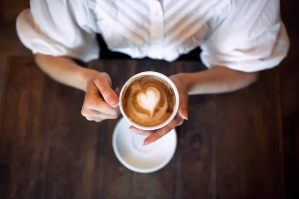 Vista superior de una mujer irreconocible sentada en el interior de la cafetería, sosteniendo el café . —  Fotos de Stock