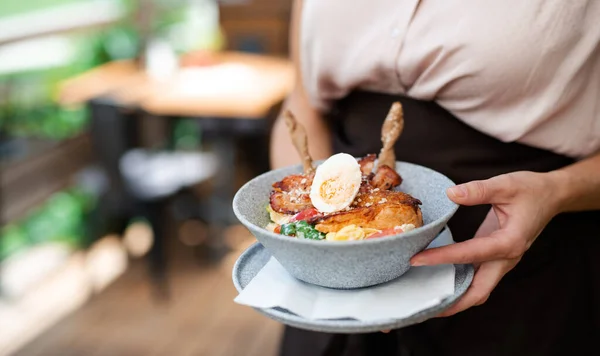 Unerkennbare Kellnerin mit Teller steht auf Terrassenrestaurant, Mittelteil. — Stockfoto