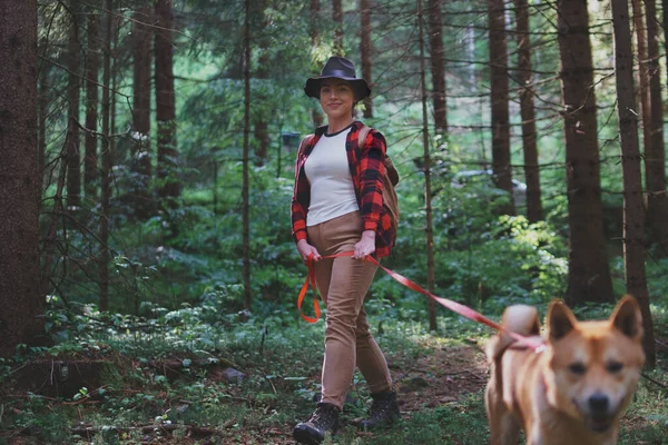 Mujer joven con un perro en un paseo al aire libre en el bosque en la naturaleza de verano . —  Fotos de Stock