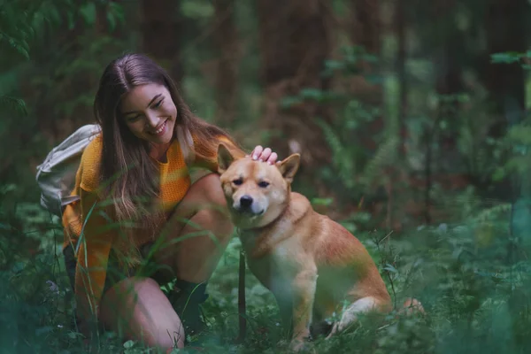 Mujer joven con un perro en un paseo al aire libre en la naturaleza de verano . —  Fotos de Stock