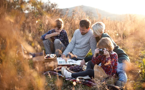 Belle jeune famille avec de jeunes enfants pique-niquer en automne nature. — Photo