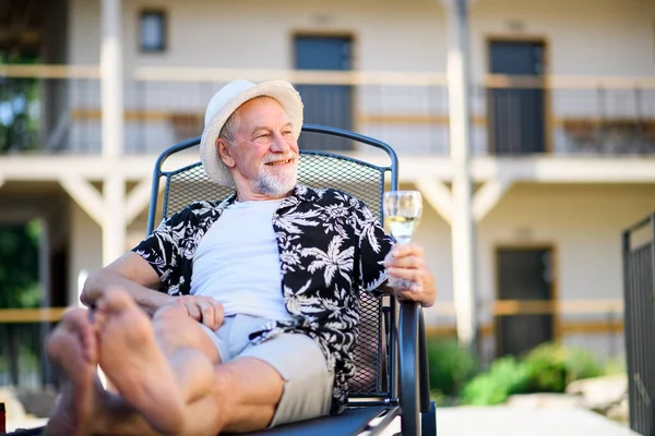 Старший чоловік тримає вино на відкритому повітрі у відпустці, розслабляючись . — стокове фото
