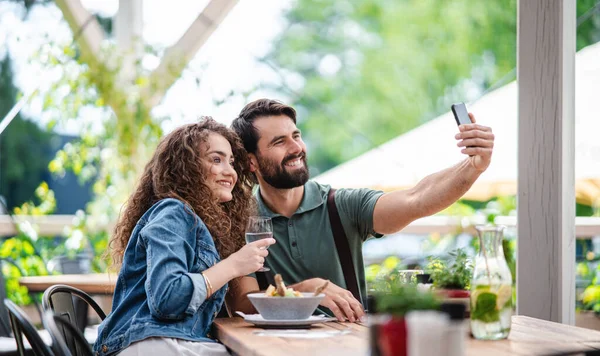 Teras restoranında oturup selfie çeken mutlu bir çift.. — Stok fotoğraf