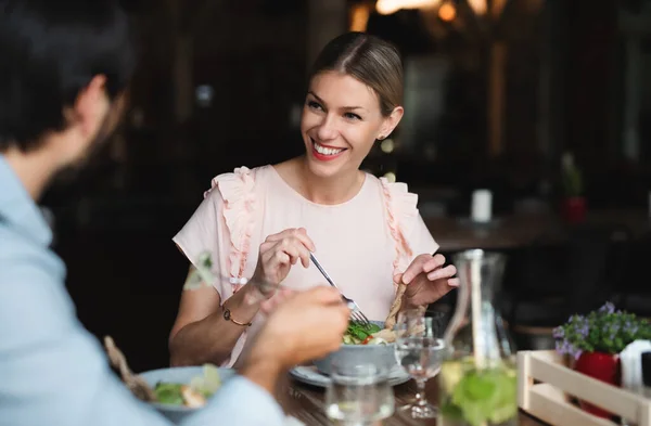 Pareja feliz sentada en el interior del restaurante, comiendo . — Foto de Stock