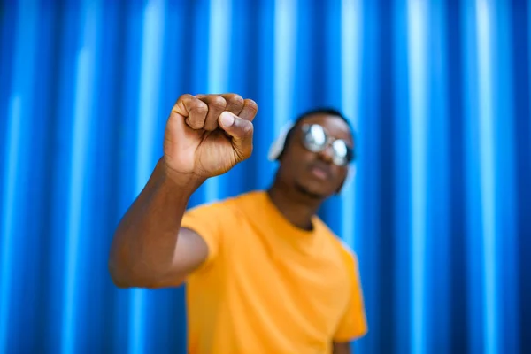 Homem negro com punho levantado de pé contra fundo azul, preto vive conceito matéria . — Fotografia de Stock