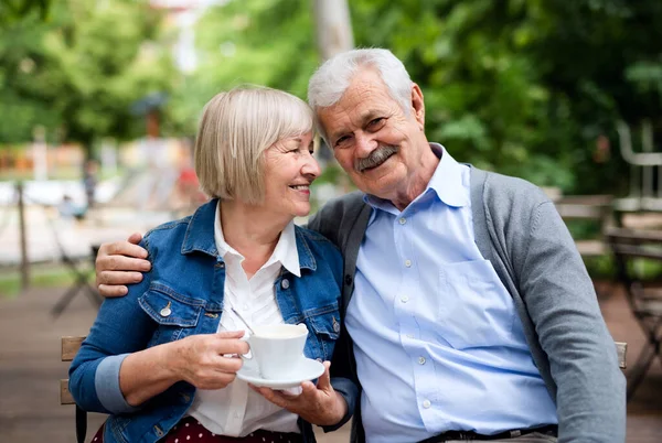 Šťastný starší pár v lásce sedí venku v kavárně, baví. — Stock fotografie
