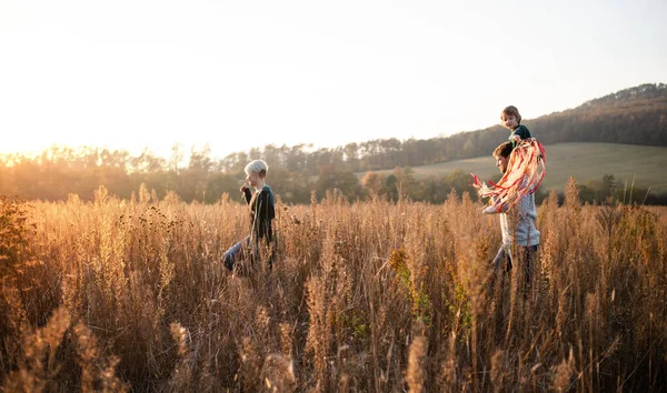 Vista lateral de la familia con hija pequeña en un paseo en la naturaleza de otoño. —  Fotos de Stock