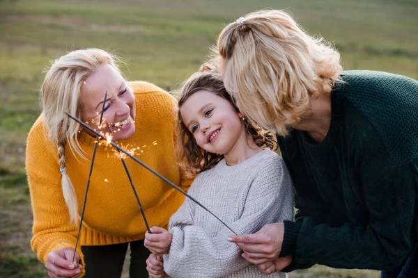 Klein meisje met moeder en oma op een wandeling in de natuur, met sterretjes. — Stockfoto