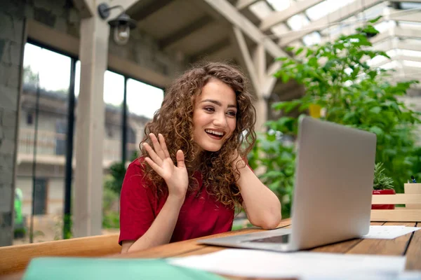 Ung kvinna sitter inomhus i grönt kontor, konferens business call koncept. — Stockfoto