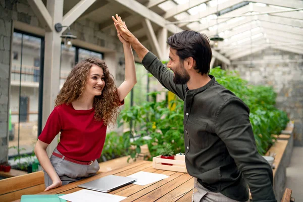 Joven hombre y mujer sentados en el interior de la oficina verde, concepto de reunión de negocios. — Foto de Stock