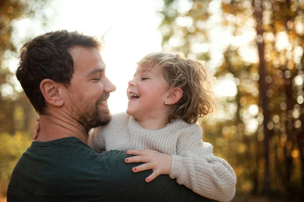 Reifer Vater hält kleine Tochter beim Spaziergang im Herbstwald. — Stockfoto