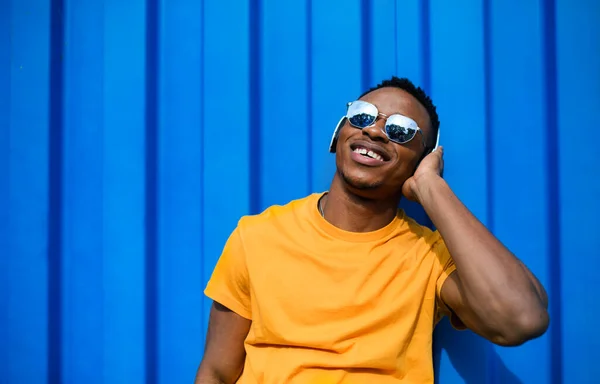 Joven hombre negro con gafas de sol de pie sobre fondo azul, negro vive concepto de la materia. —  Fotos de Stock