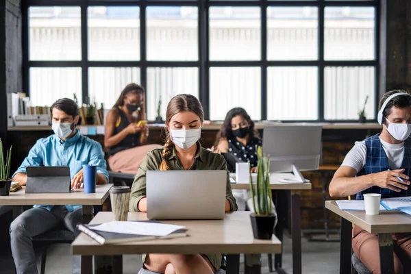 Potret para pengusaha muda dengan topeng wajah yang bekerja di dalam ruangan di kantor. — Stok Foto