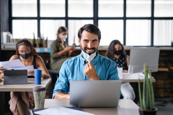 Portrait of young businesspeople with face masks working indoors in office. — Stock Photo, Image
