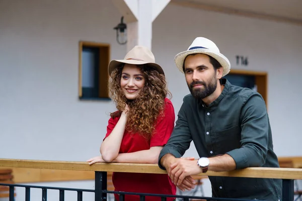 Pareja joven parada al aire libre por el hotel de vacaciones, relajante. — Foto de Stock