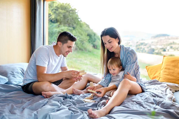 Young family with small daughter indoors, weekend away in container house in countryside. — Stock Photo, Image