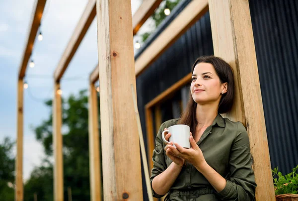 Young woman outdoors, weekend away in container house in countryside. — Stock Photo, Image