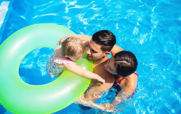 Draufsicht auf junge Familie mit kleiner Tochter im Freibad. — Stockfoto