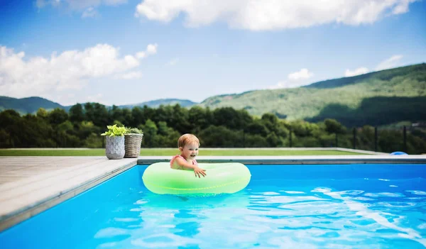 Portret van kleine peuter meisje in het zwembad buiten in de achtertuin. — Stockfoto