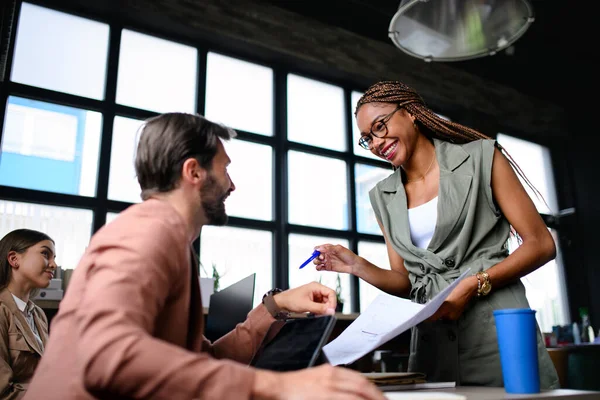 Porträt junger Geschäftsleute, die drinnen im Büro arbeiten und miteinander reden. — Stockfoto