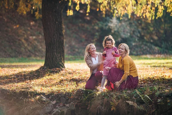Annesi ve büyükannesiyle birlikte sonbahar ormanında dinlenen küçük bir kız.. — Stok fotoğraf