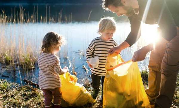 Babası ve küçük çocukları doğada çöp topluyor, konsept yapıyor.. — Stok fotoğraf