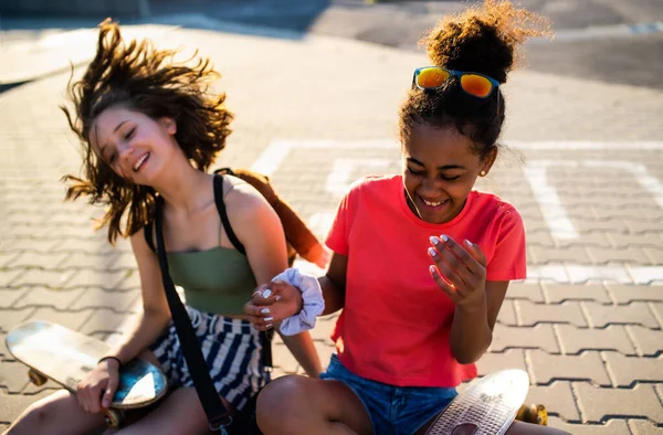 Nastolatki dziewczyny przyjaciele z deskorolkami siedzi na świeżym powietrzu w mieście. — Zdjęcie stockowe