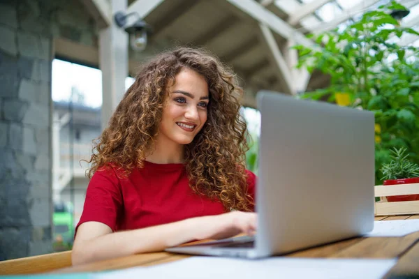 Mladá žena sedí v kanceláři a používá notebook. — Stock fotografie