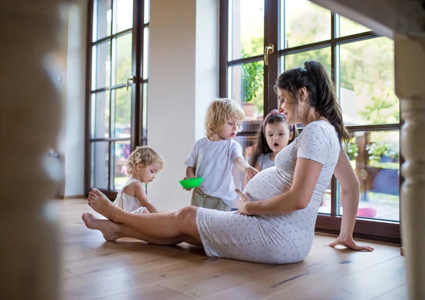 집안에 어린 자녀들이 있는 임신부가 집에서 놀고 있다. — 스톡 사진