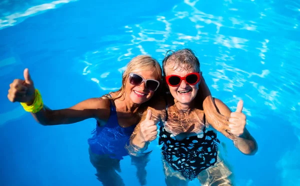 Vista de ángulo alto de las mujeres mayores alegres en la piscina al aire libre en el patio trasero. —  Fotos de Stock