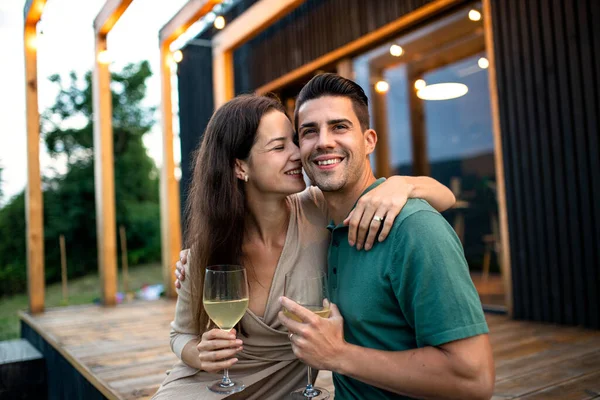Junges Paar mit Wein im Freien, Wochenende im Containerhaus auf dem Land. — Stockfoto
