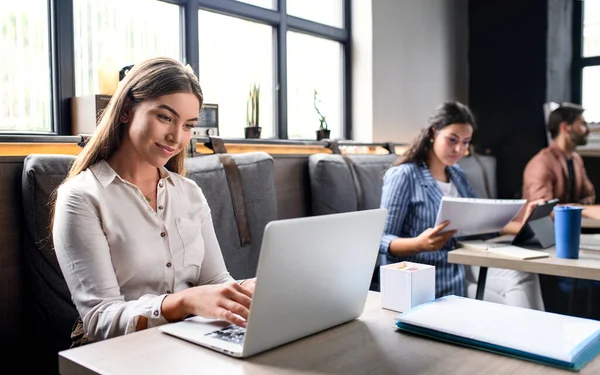 Porträt junger Geschäftsleute mit Laptop im Büro. — Stockfoto