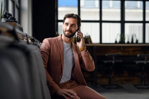 Портрет молодого бізнесмена зі смартфоном в приміщенні офісу, дивлячись на камеру . — стокове фото