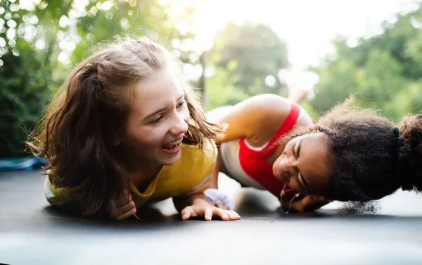 Vista frontal de jovens amigas adolescentes ao ar livre no jardim, rindo. — Fotografia de Stock