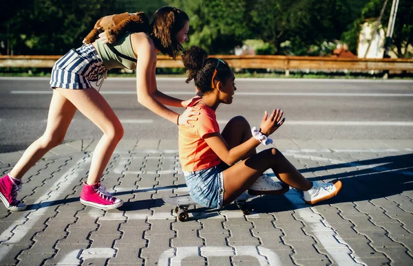 Gadis remaja berteman dengan skateboard di luar kota, bersenang-senang. — Stok Foto