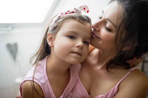 Moeder en kleine dochter binnen thuis, knuffelen. — Stockfoto